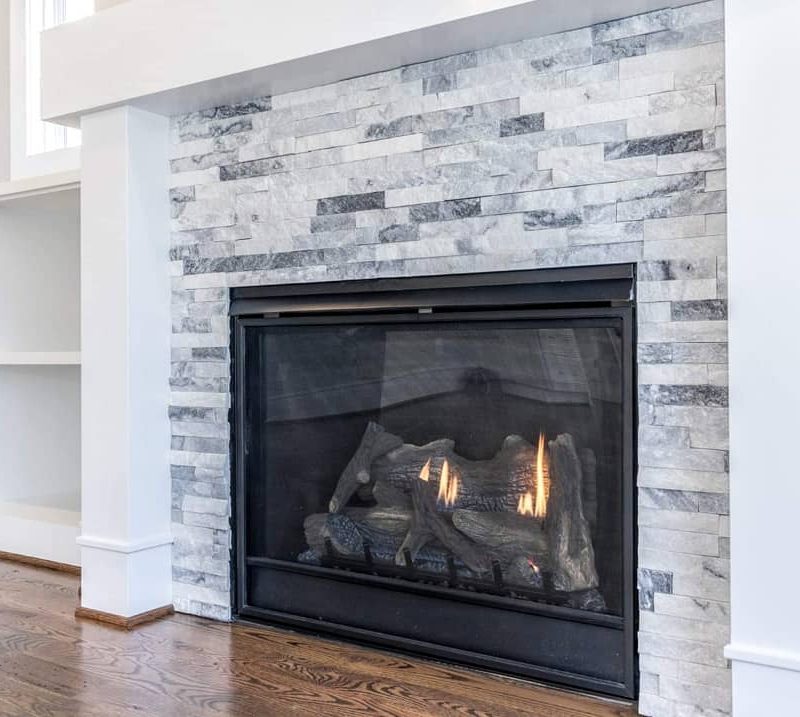 White and grey splitface quartzite stacked stone fireplace